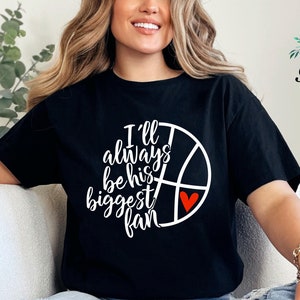 Gildan unisex basketball mom T-shirt featuring a basketball and heart graphic with the message “I’ll always be his biggest fan.”