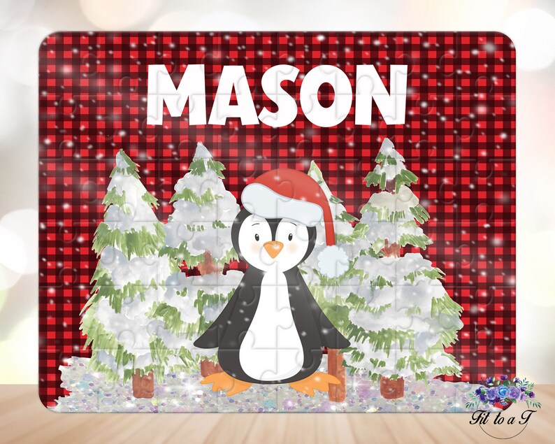 May include: A rectangular jigsaw puzzle featuring a red and black buffalo plaid background with the name MASON in white capital letters. The design includes a cartoon penguin wearing a red Santa hat, surrounded by snow-covered evergreen trees.