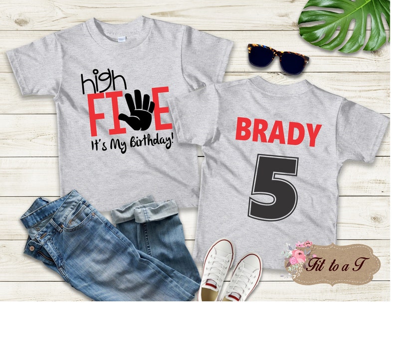May include: Gray t-shirt with the text "high five" in red and a black handprint. The text "It's my birthday!" is also in red. The back of the shirt has the name "BRADY" in red and the number "5" in black.