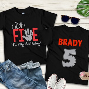 May include: Two black t-shirts. One shirt says "high FIVE" with a hand print and "It's my birthday!" The other shirt says "BRADY" and has the number "5" in gray.