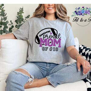 A gray t-shirt with a football graphic and the words "proud MOM".  May be customized with your favorite player's number.