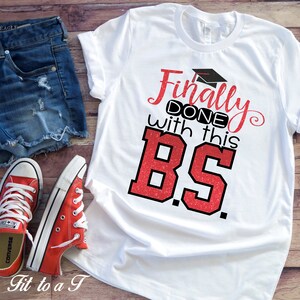 May include: White t-shirt with red glitter text that says "Finally Done with this BS."  The text is in a bold, blocky font.  A graduation cap is above the word "Finally".