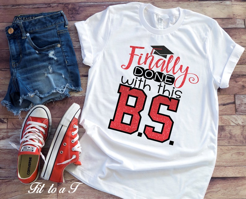 May include: White t-shirt with red glitter text that says "Finally Done with this BS."  The text is in a bold, blocky font.  A graduation cap is above the word "Finally".