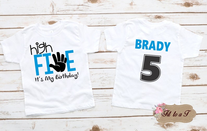 May include: Two white t-shirts with blue and black text. The front of one shirt says "high FIVE" with a black handprint and "It's My Birthday!" The back of the other shirt says "BRADY 5" in blue and black text.