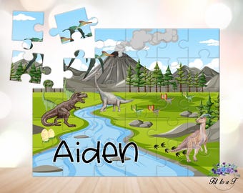 May include: A colorful dinosaur-themed jigsaw puzzle with a blue river, green grass, and a volcano. The puzzle is personalized with the name "Aiden".
