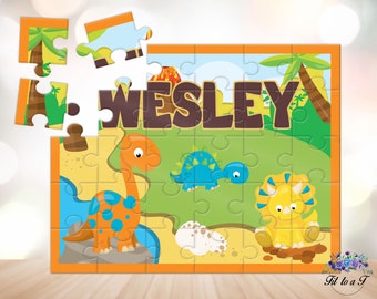 May include: A rectangular jigsaw puzzle featuring a cartoon dinosaur scene with the name WESLEY in large brown letters. The image includes a long-necked orange dinosaur, a blue stegosaurus, a yellow triceratops, a volcano, and palm trees.