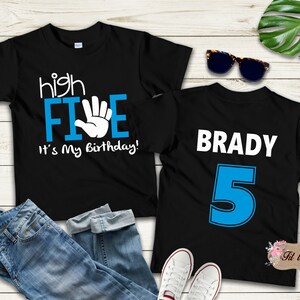 May include: Two black t-shirts with blue and white text. The first shirt says "high FIVE it's my birthday!" with a white hand making a high five. The second shirt says "BRADY 5" in white text with a blue number 5.