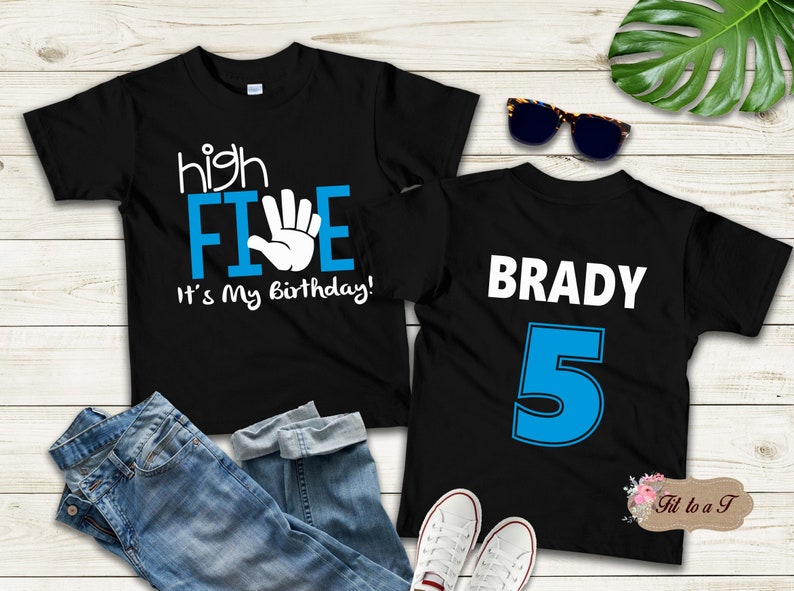 May include: Two black t-shirts with blue and white text. The first shirt says "high FIVE it's my birthday!" with a white hand making a high five. The second shirt says "BRADY 5" in white text with a blue number 5.