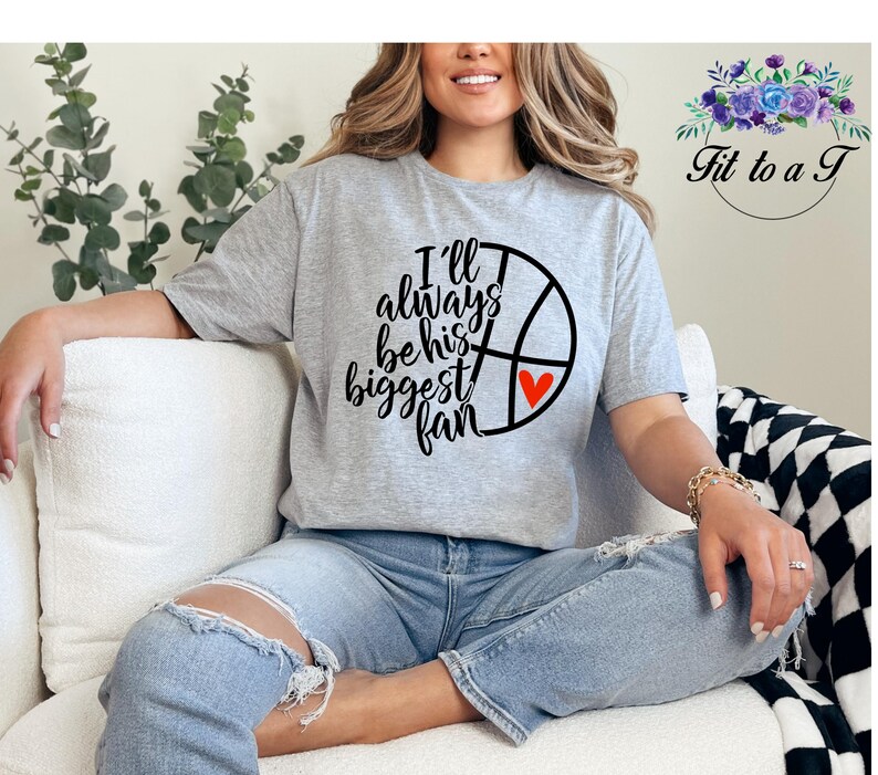 Gildan unisex basketball mom T-shirt featuring a basketball and heart graphic with the message “I’ll always be his biggest fan.”