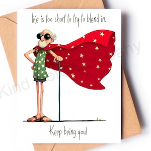 May include: Greeting card with an illustration of an elderly person wearing a red cape with white stars and a green shirt with stars. The card reads "life is too short to try to blend in. Keep being you!" and is inside a brown envelope.