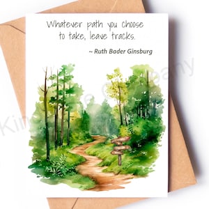 May include: A greeting card with a watercolor illustration of a path winding through a forest, with the quote "Whatever path you choose to take, leave tracks." by Ruth Bader Ginsburg. The card is on a brown envelope.
