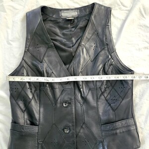 Puede incluir: Chaleco de cuero negro con cuello en V y dise&ntilde;o de patchwork en forma de diamante. El chaleco tiene dos bolsillos y tres botones en la parte delantera. El chaleco mide aproximadamente 43 cm de ancho.