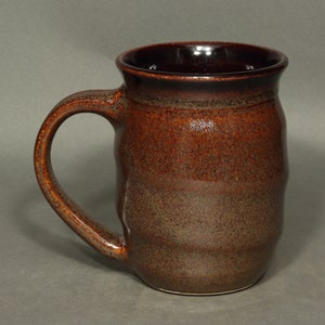 A barrel shaped mug with spiral ridges climbing the sides.  The spiral starts with the bottom of the handle and continues to the top of the handle.  The handle is has a pleasant curve.