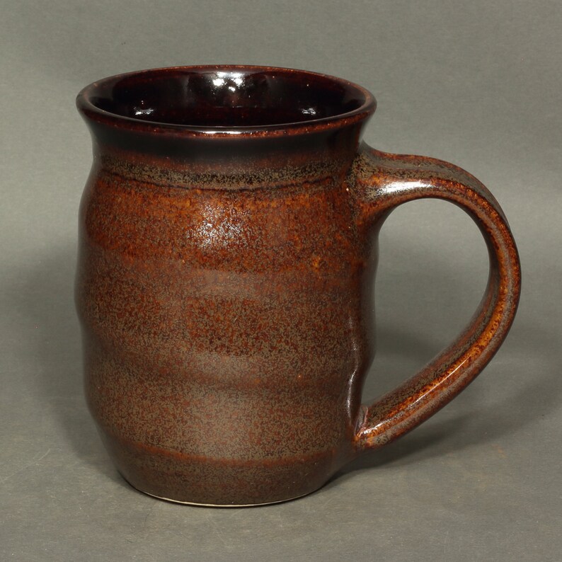 A barrel shaped mug with spiral ridges climbing the sides.  The spiral starts with the bottom of the handle and continues to the top of the handle.  The handle is has a pleasant curve.