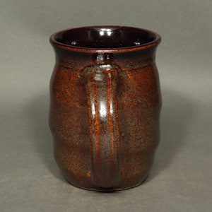 A barrel shaped mug with spiral ridges climbing the sides.  The spiral starts with the bottom of the handle and continues to the top of the handle.  The handle is has a pleasant curve.