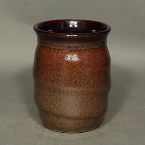 A barrel shaped mug with spiral ridges climbing the sides.  The spiral starts with the bottom of the handle and continues to the top of the handle.  The handle is has a pleasant curve.