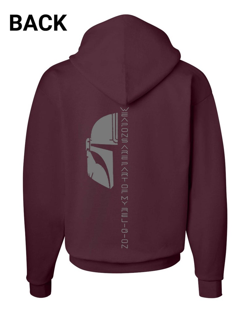 Puede incluir: Sudadera con capucha color burdeos con un gr&aacute;fico de casco mandaloriano gris y el texto "This is the way" en escritura mandaloriana en la parte posterior.