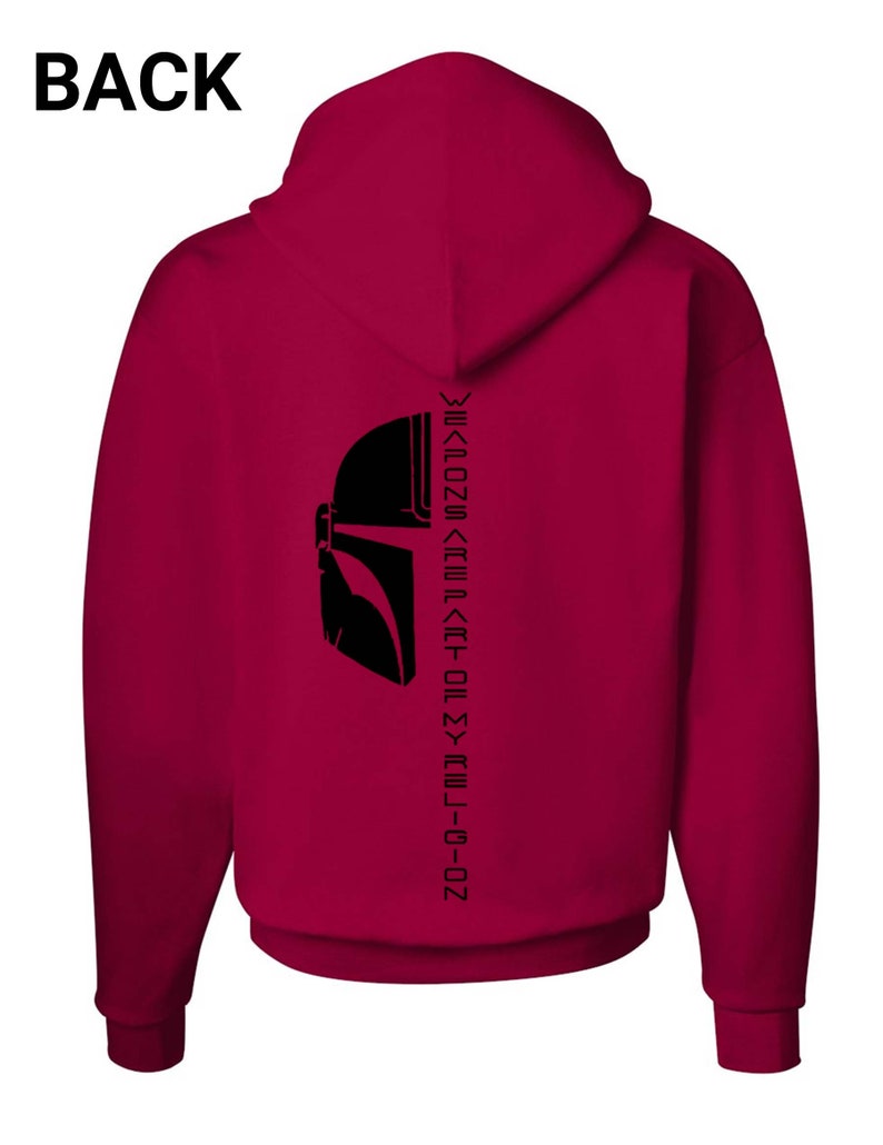 Puede incluir: Una sudadera con capucha color granate con una silueta negra de un casco mandaloriano y el texto "This is the way" escrito verticalmente en la espalda.