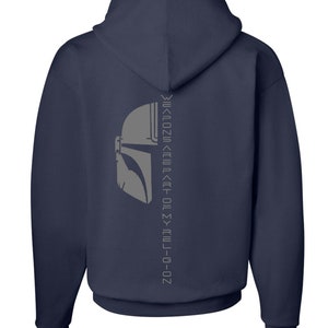Puede incluir: Sudadera con capucha azul marino con un gr&aacute;fico de casco de Mandaloriano gris y el texto "This is the way" en una l&iacute;nea vertical en la espalda.