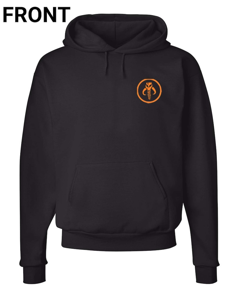 Puede incluir: Sudadera con capucha negra con un s&iacute;mbolo mandaloriano naranja en la parte delantera.