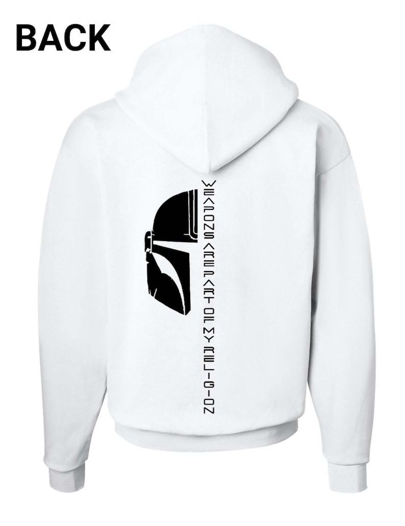 Puede incluir: Sudadera con capucha blanca con una silueta negra de un casco mandaloriano y el texto "Weapons are part of my religion" impreso en la espalda.