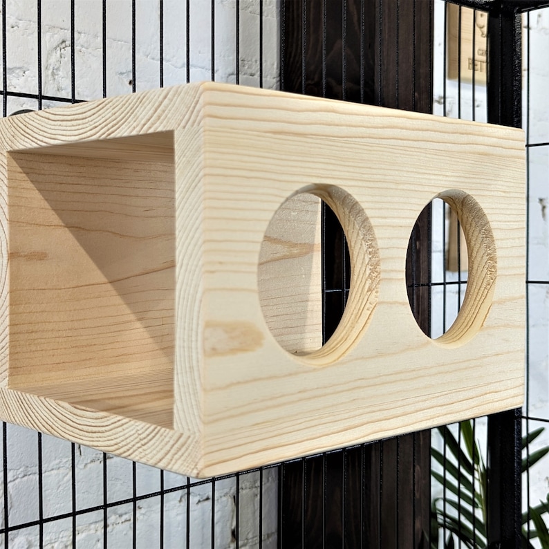 May include: A wooden cat toy with two round holes. The toy is made of natural wood and has a light brown color.