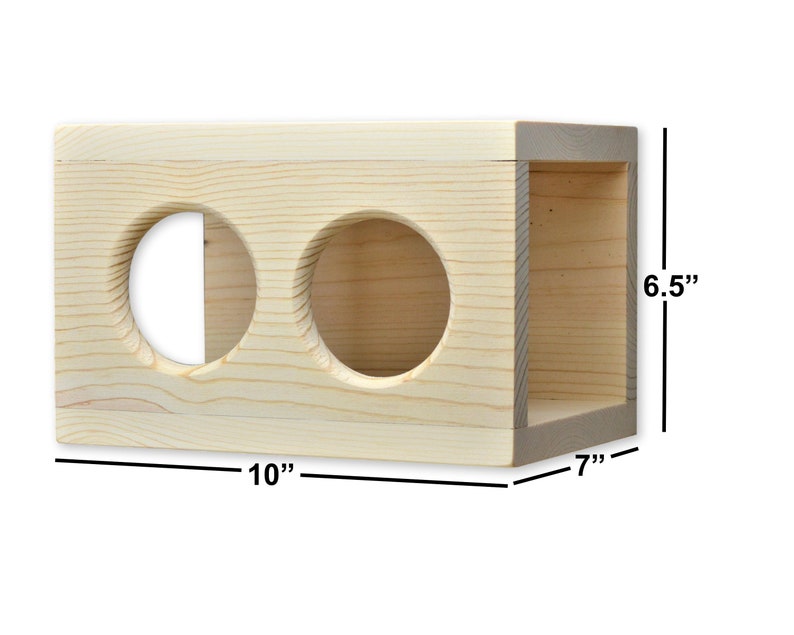 May include: A natural wood cat toy with two round holes. The toy measures 10 inches wide, 7 inches deep, and 6.5 inches tall.