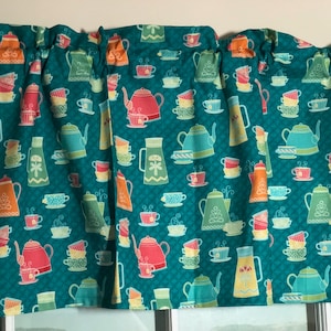 May include: Teal fabric valance with a repeating pattern of teapots and teacups in various colors, including red, orange, yellow, green, and blue.