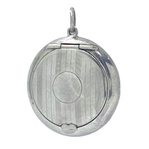May include: A silver-coloured, round locket pendant with a hinged lid. The locket has a vertically striped design on the front and a small circular detail in the centre. A small loop is at the top for attaching to a chain.