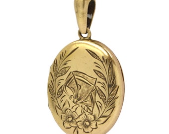 May include: A gold oval locket with a floral design engraved on the front. The locket has a loop at the top for attaching a chain.