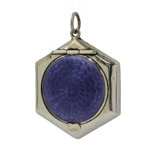 May include: A silver locket with a hexagonal shape and a hinged lid. The locket has a blue enamel interior with a swirling pattern.