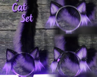 以下が含まれることがあります： 紫色の猫耳ヘッドバンドと尻尾のセット。ヘッドバンドは、黒のヘッドバンドに紫と白の毛皮の猫耳が付いています。尻尾は、長くふわふわとした紫と白の尻尾です。