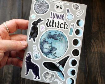 May include: A sheet of stickers with a gray background featuring a black wolf howling, a black rabbit, a witch's hat, a moon, a bottle, crystals, and the text "LUNAR witch".