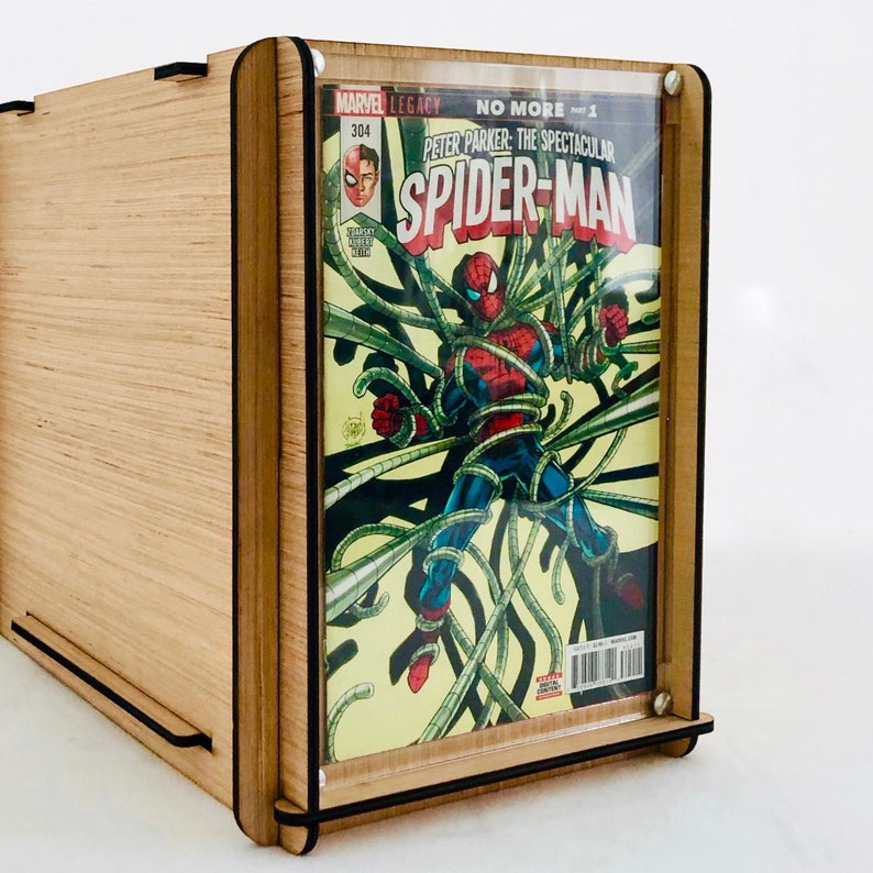 Pu&ograve; includere: Una teca in legno per fumetti con un fronte in acrilico trasparente. La teca contiene un fumetto di Spider-Man con il titolo "No More" e il numero dell'edizione "1". La copertina del fumetto presenta Spider-Man in un design a ragnatela.