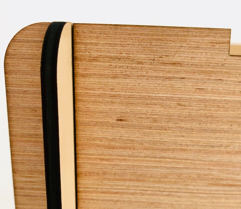 Pu&ograve; includere: Primo piano di una scatola di legno con un elastico nero. La scatola ha una venatura del legno marrone chiaro e una finitura naturale.