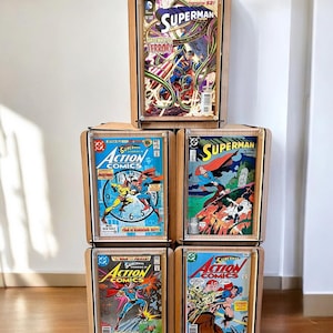 Pu&ograve; includere: Un set di quattro fumetti con Superman e Action Comics. I fumetti sono esposti in cornici di legno su uno scaffale. I fumetti sono tutti in buone condizioni e hanno colori vivaci. I fumetti sono tutti di numeri diversi e hanno copertine diverse.