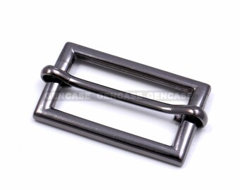 May include: A black metal slider buckle for a belt or strap. The buckle has a rectangular shape with a smooth, matte finish.