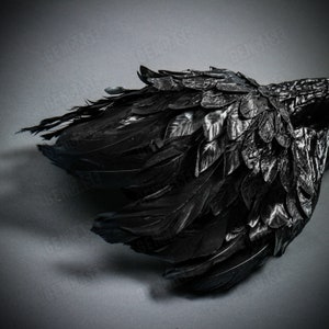 K&ouml;nnte beinhalten: Schwarze Fl&uuml;gel aus Federn mit einem strukturierten, geschichteten Design. Die Fl&uuml;gel bestehen aus mehreren Federn, die in Schichten angeordnet sind und so ein realistisches und dramatisches Aussehen erzeugen.