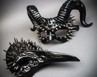 May include: Two black masquerade masks with silver spikes. One mask has horns and the other has a long beak.