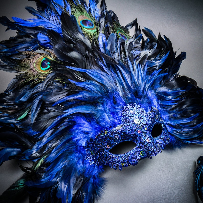 May include: A blue and black masquerade mask with peacock feathers. The mask is decorated with rhinestones and has a delicate lace design.