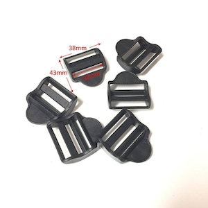 May include: Six black plastic slider buckles, each with two slots. The buckles measure 38mm wide and 43mm long.