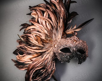 May include: A black and brown masquerade mask with a lace design and a large plume of brown feathers. The mask has a single eye hole and is decorated with rhinestones.