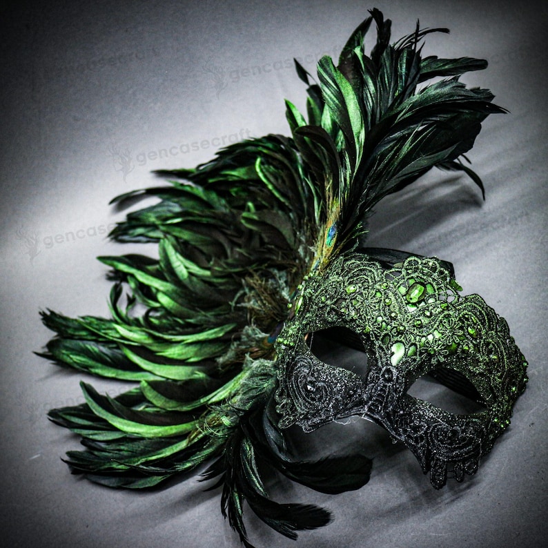 Peut inclure: Un masque de mascarade d&eacute;coratif avec un design demi-visage. Le masque pr&eacute;sente des d&eacute;tails en dentelle noire et verte, orn&eacute;s de pierres pr&eacute;cieuses vertes. De longues plumes vertes et une plume de paon unique accentuent le masque.