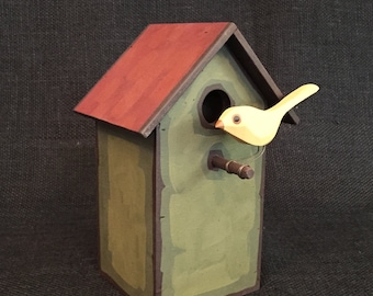 Casinha de pássaros decorativa com pássaros de madeira esculpidos à mão.