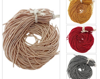 May include: A close-up of four spools of metallic beading cord. The spools are in the colors gold, red, silver, and rose gold.