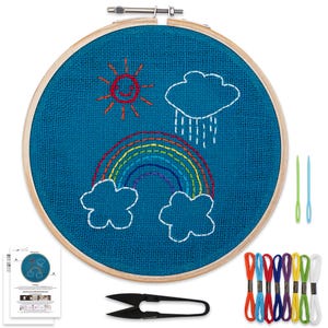 Può includere: Kit da ricamo con telaio in legno e sfondo in juta blu. Il disegno rappresenta un arcobaleno, un sole e delle nuvole. Il kit include filo da ricamo di vari colori, due aghi e forbici da ricamo.