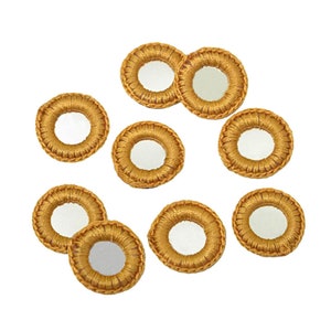 以下が含まれることがあります： 10個の金色の円形装飾要素のコレクション。各要素は、織り込まれたテクスチャのあるボーダーで囲まれた中央の鏡面を備えています。要素は白い背景に配置されています。