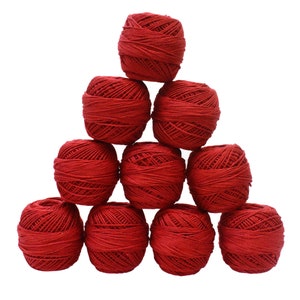May include: A pyramid of ten red yarn balls, tightly wound and arranged against a white background. The yarn appears to be a medium weight, suitable for various crafting projects. The balls are evenly sized and create a visually appealing display.