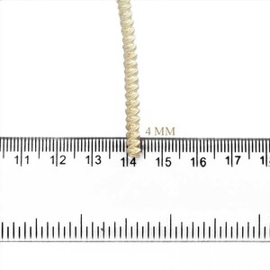May include: A close-up of a cream-colored braided trim with a ruler showing it is 4 mm wide.