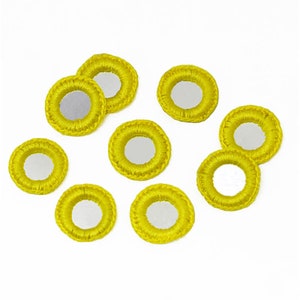 May include: Ten yellow round mirror embellishments with a crocheted border.
